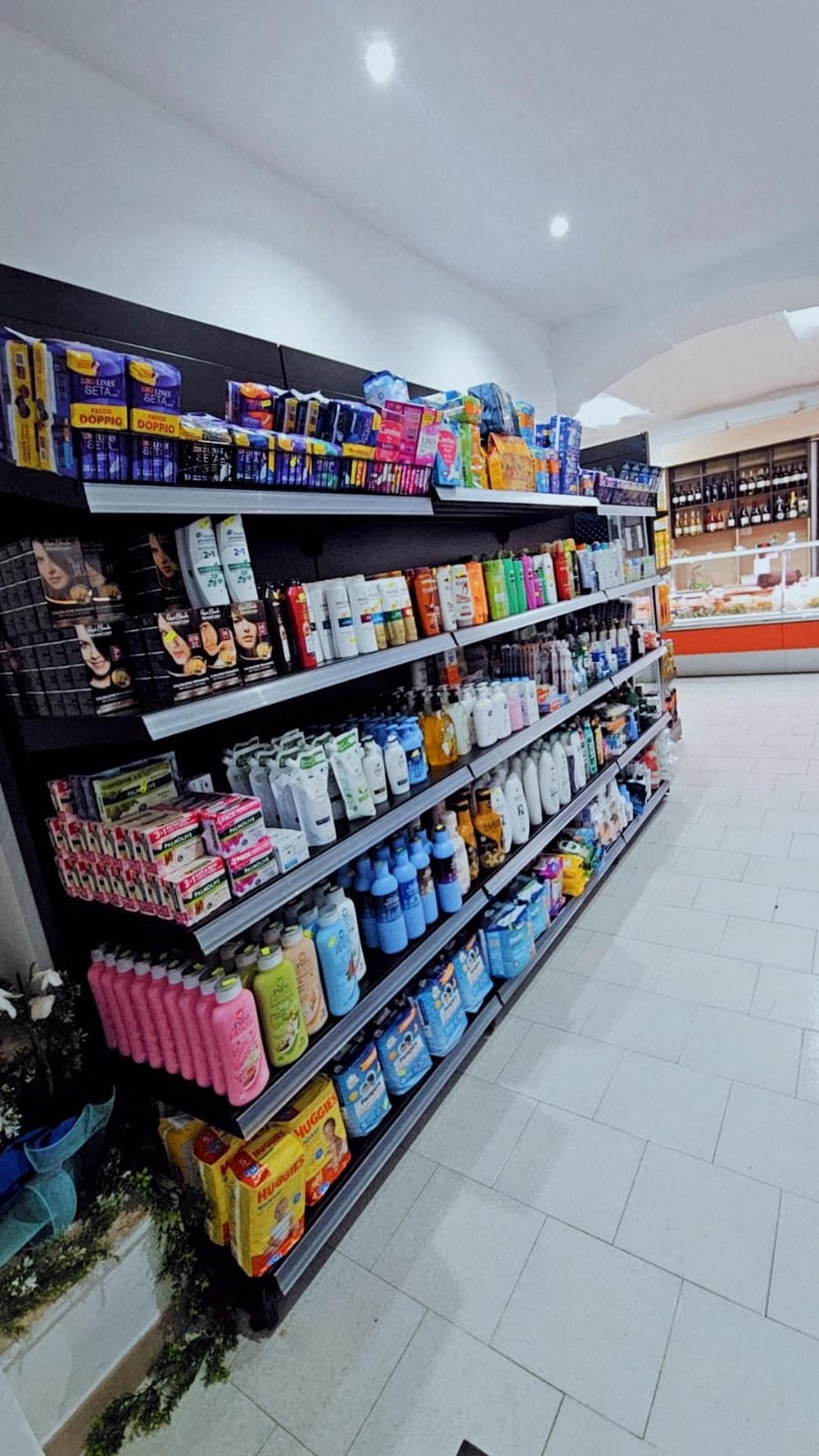 Scaffale di shampoo, bagnoschiuma, saponi, assorbenti e pannolini
